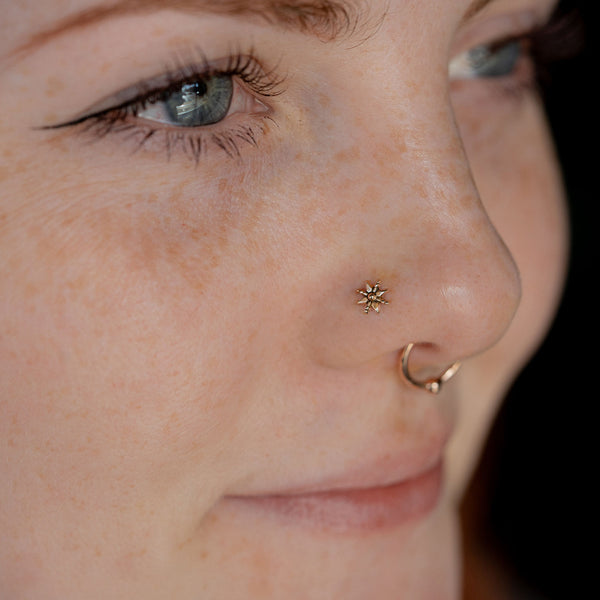 Nostril Piercing by @GrumblesPiercings On IG; Featuring a petite beaded gold nose ring